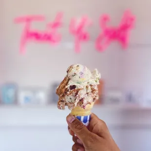 a hand holding an ice cream cone
