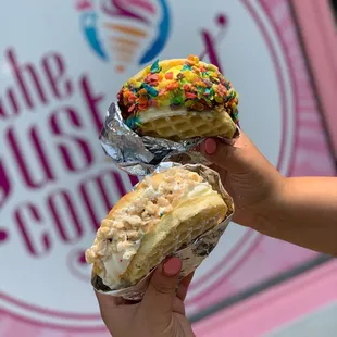 a hand holding a half eaten ice cream sandwich