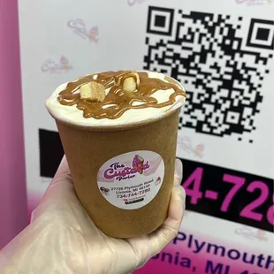 a person holding a cup of ice cream