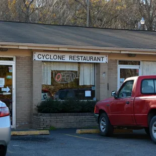 a red truck parked in front of a restaurant