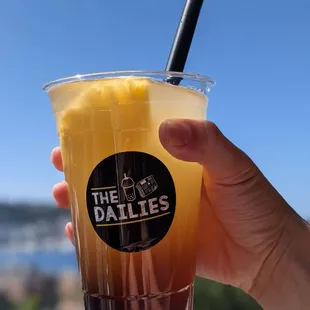 a hand holding a drink with a straw