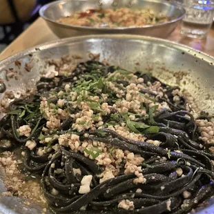 a plate of pasta with meat and herbs