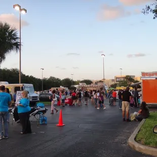 a crowd of people standing in a parking lot
