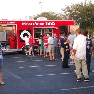 a crowd of people standing in a parking lot