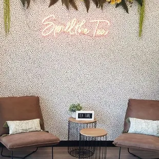 two chairs in front of a floral wall