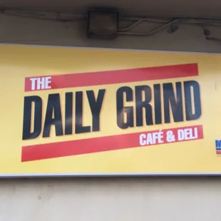 a sign for the daily grind cafe and deli