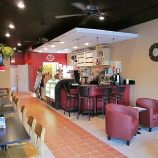 a restaurant with red chairs and a bar