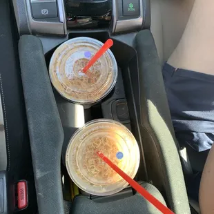 two plastic cups in the center console of a car
