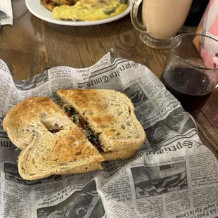 Light and Fit sandwich and black coffee in the foreground, omelet with potatoes and The Daily latte in the background