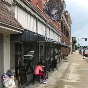 people sitting outside of a coffee shop