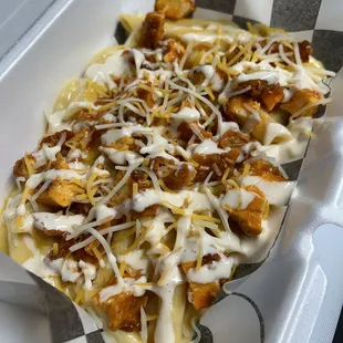 Buffalo fried chicken over Mac &amp; Cheese with a blue cheese drizzle
