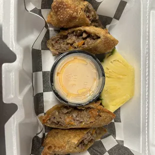Philly Cheesesteak Egg Rolls with cheese sauce for dipping &amp; our signature slice of pineapple on the side