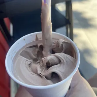a person holding a cup of ice cream