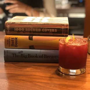 a stack of books and a drink