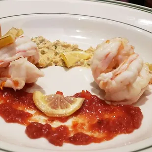 a plate of food with shrimp and lemon slices