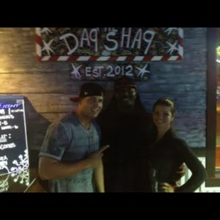 three men standing in front of a bar