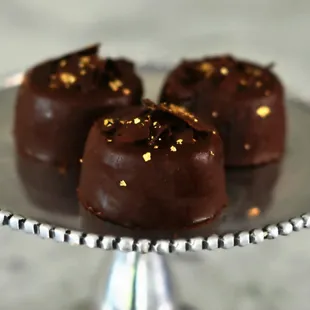 Flourless Decadence mini cakes. Topped with chocolate shavings and edible gold! The perfect gift.