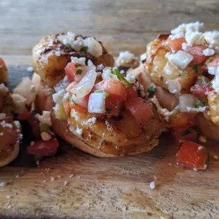 Marinated shrimp served with avocado crema, zesty pineapple, cotija cheese &amp; pico on crostini