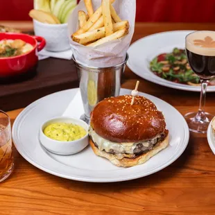 a burger, chips, and a drink on a table