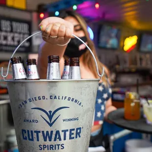 a woman holding a bucket of beer