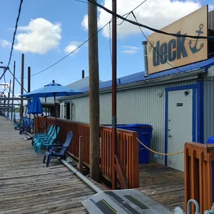 a dock with chairs and umbrellas