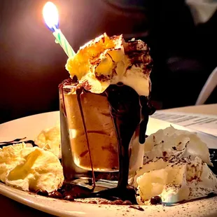 a chocolate sundae with a lit candle