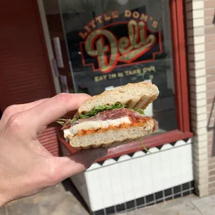 a hand holding a sandwich