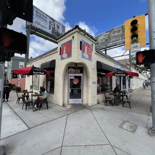 a street corner with tables and umbrellas