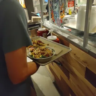 a man holding a tray of food
