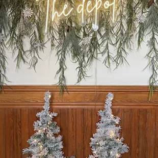 two christmas trees and a neon sign