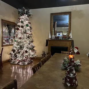 Nice area in the front of the restaurant with a family size table a tree