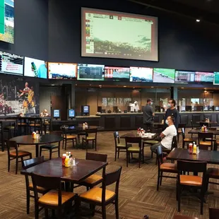 people sitting at tables and watching televisions