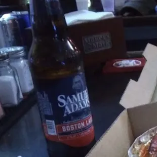 a box of pizza and a bottle of beer