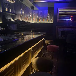 a dimly lit bar with stools