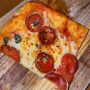 a slice of pizza on a cutting board