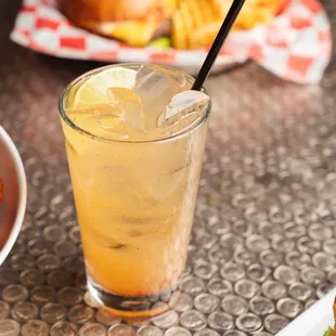 a glass of iced tea and a bowl of fried chicken