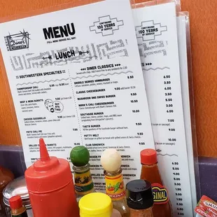 a menu and a bunch of condiments