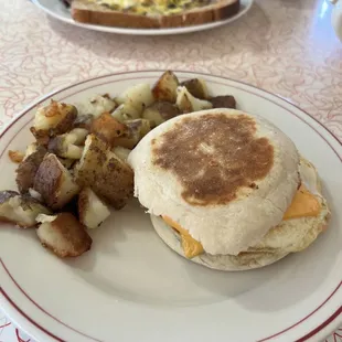 an english muffin and potatoes on a plate