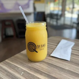 a glass of orange juice on a table