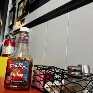 a bottle of ketchup and a basket of condiments