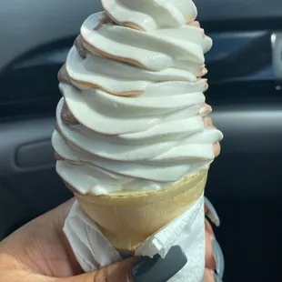 a hand holding an ice cream cone