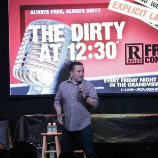 a man standing on a stage speaking into a microphone