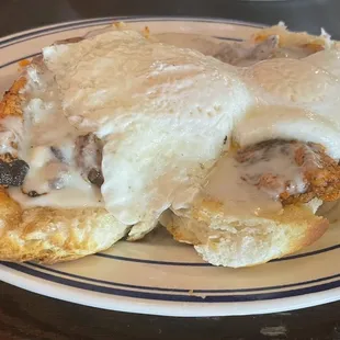 Nash trash -two biscuits split, topped with Nashville hot chicken, covered with two farm eggs, smothered in sausage gravy and syrup