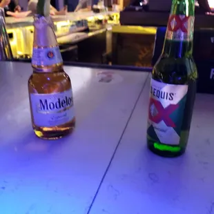 two bottles of beer on a bar