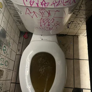 a dirty toilet with graffiti on it
