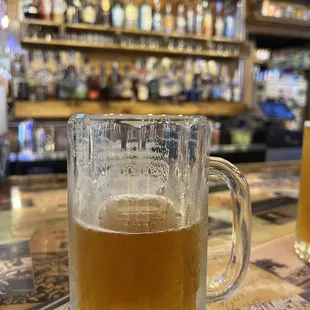 a glass of beer on a bar