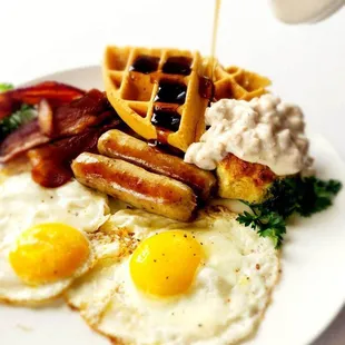 a plate of breakfast food with waffles and eggs