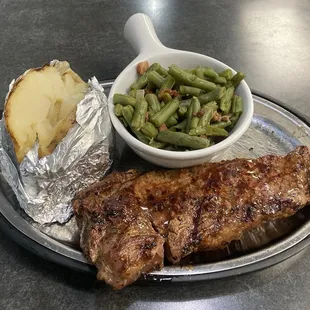 Strip steak, baked potato and green beans.