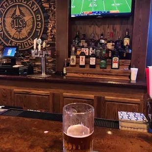 a glass of beer on a bar