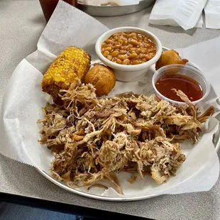 Pulled pork plate with fried corn on the cob and baked beans